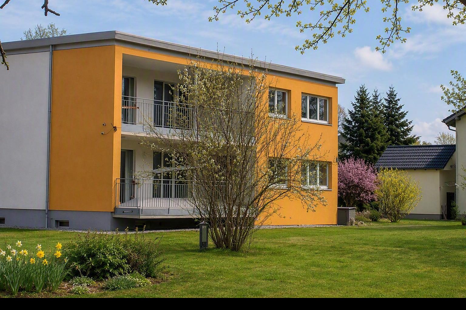Das Kanzleigebäude in der Höchster Straße 51a mit oranger Fassade, im Frühling